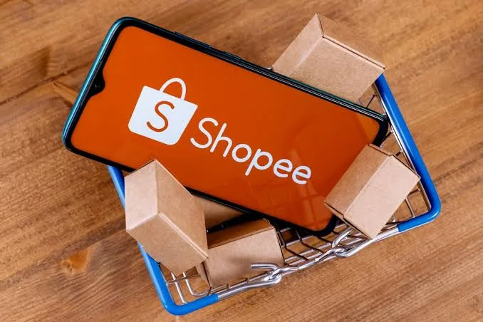 Celular com o aplicativo da Shopee em uma cesta com caixas
